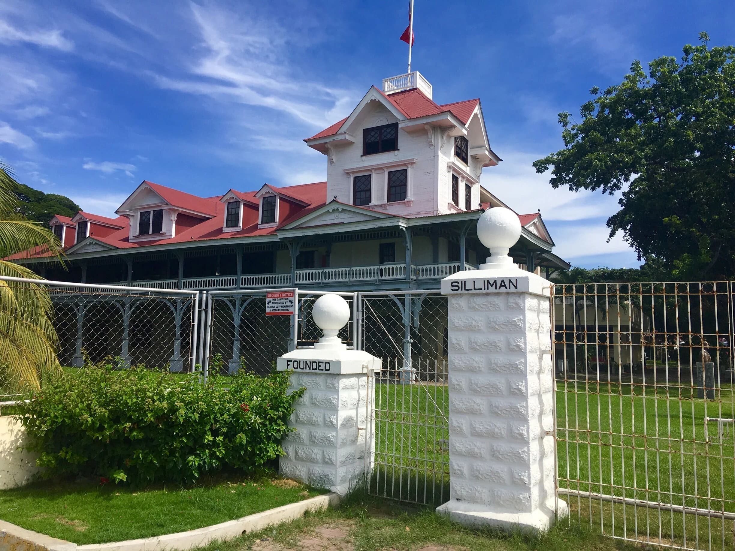 Silliman Hall behind the university's white front gate